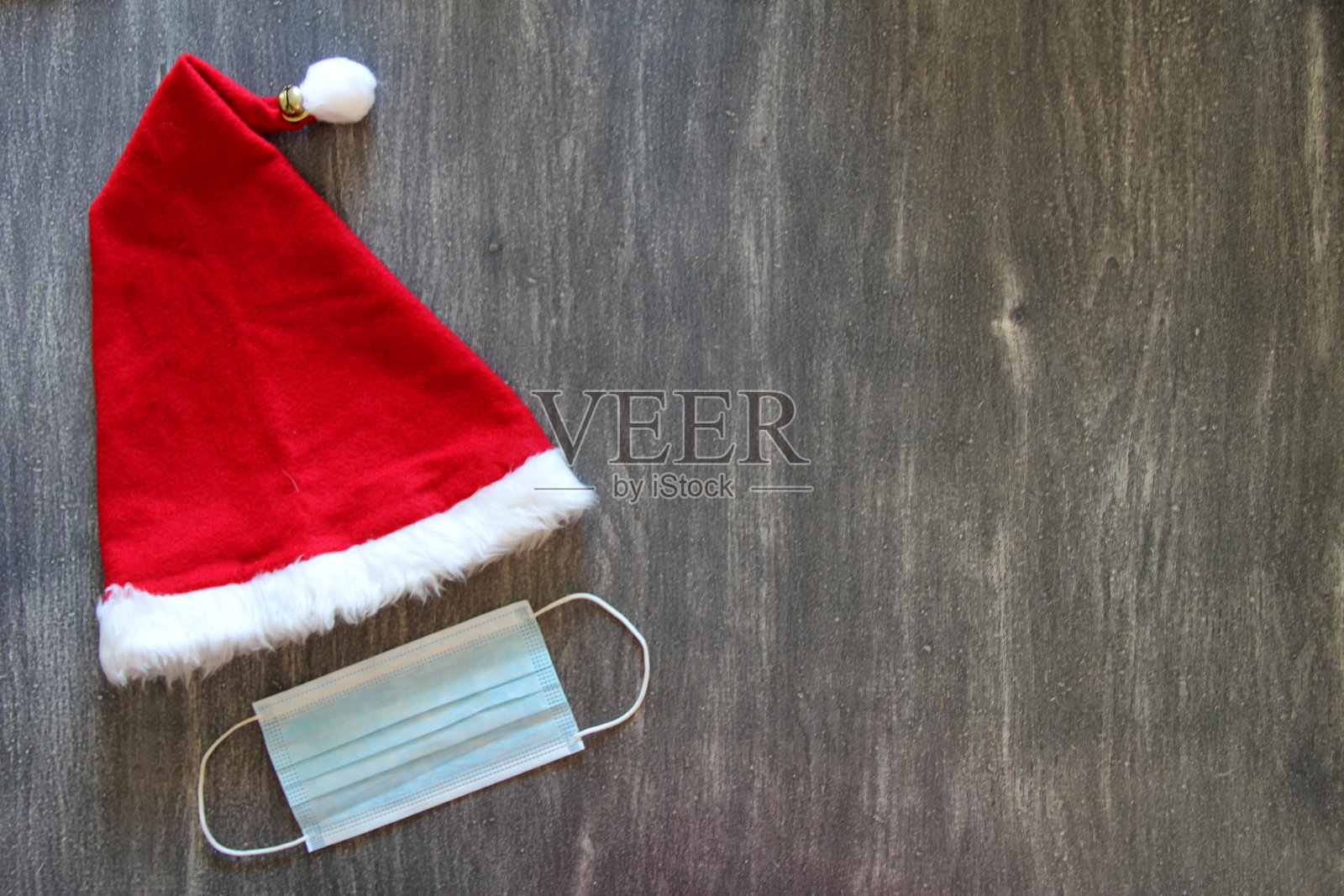圣诞老人帽和防护面具临床使用在复古的灰色背景照片摄影图片
