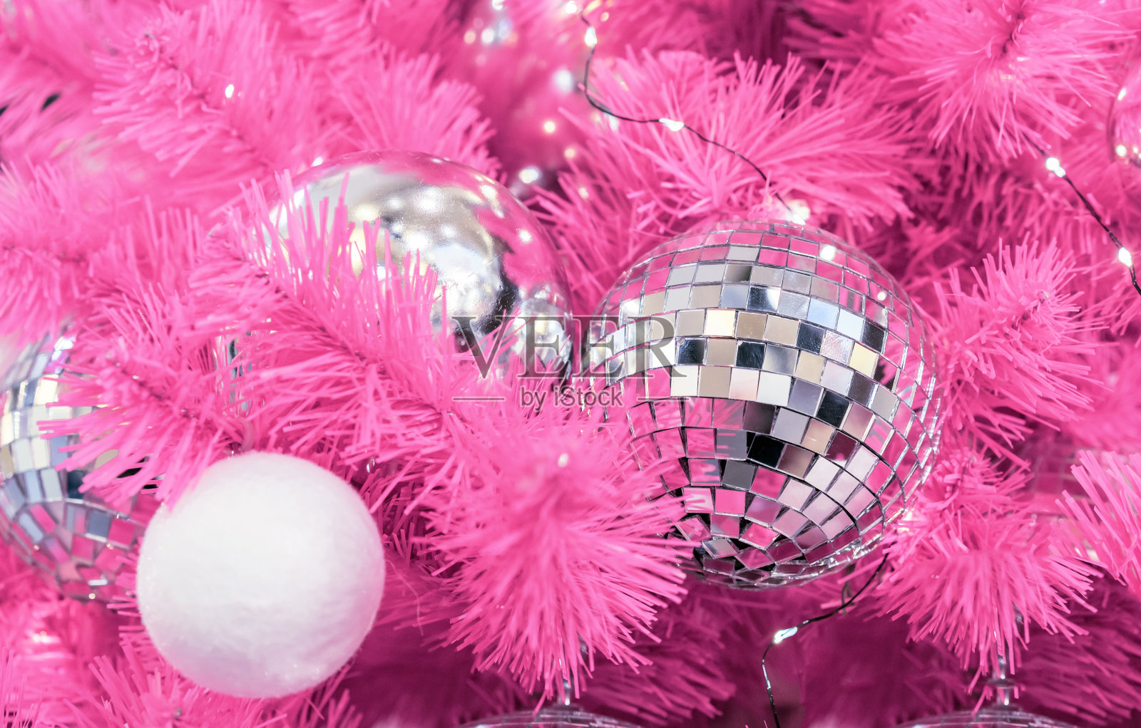 粉色圣诞树上的迪斯科球。照片摄影图片
