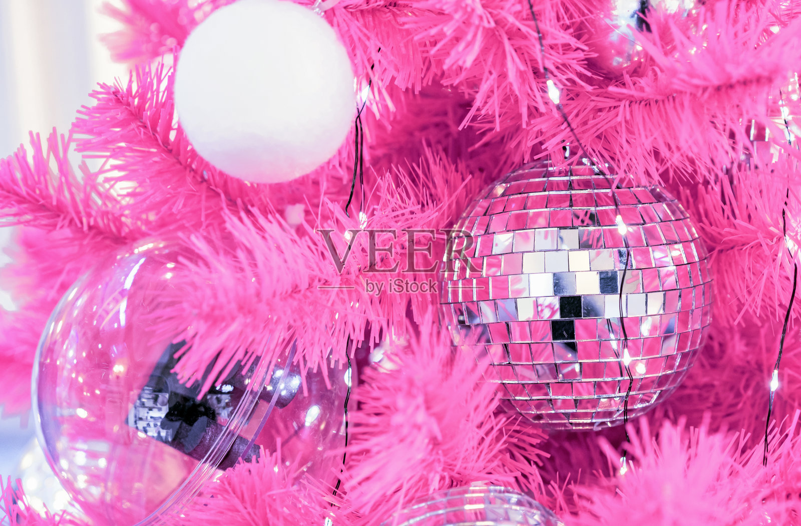 粉色圣诞树上的迪斯科球。照片摄影图片