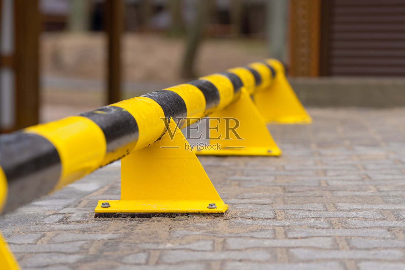 停车场有黄黑相间的金属安全围栏。照片摄影图片