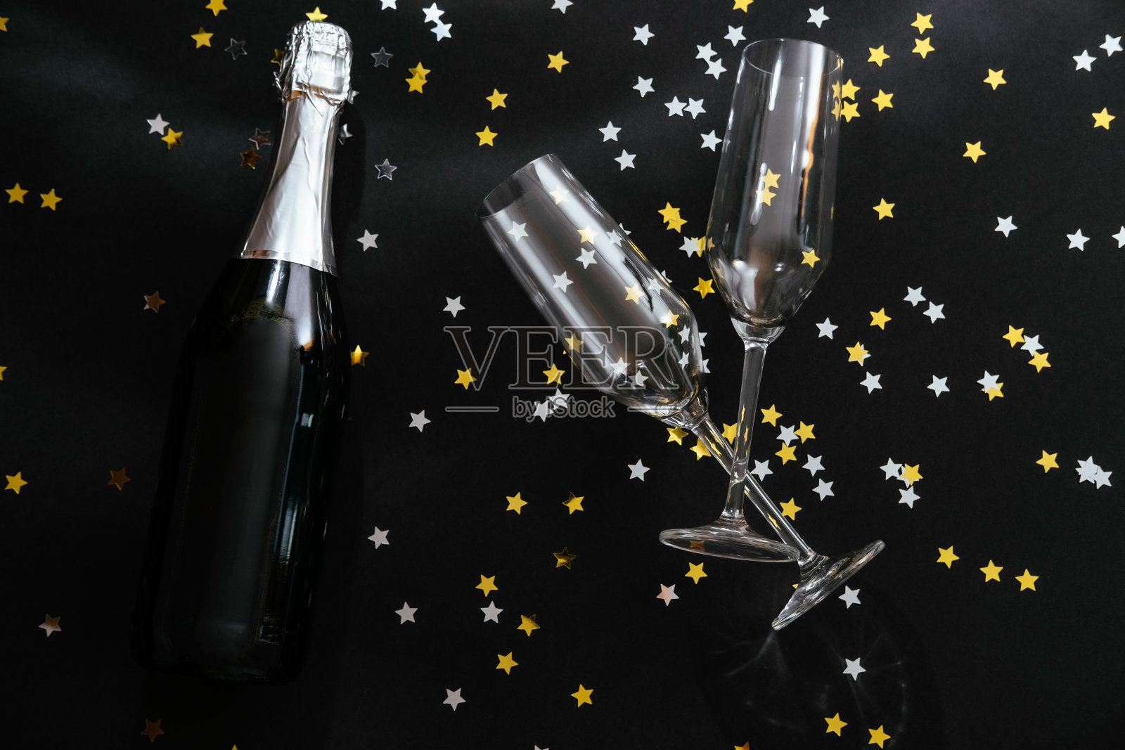 黑色背景上的香槟酒瓶和两个玻璃杯照片摄影图片