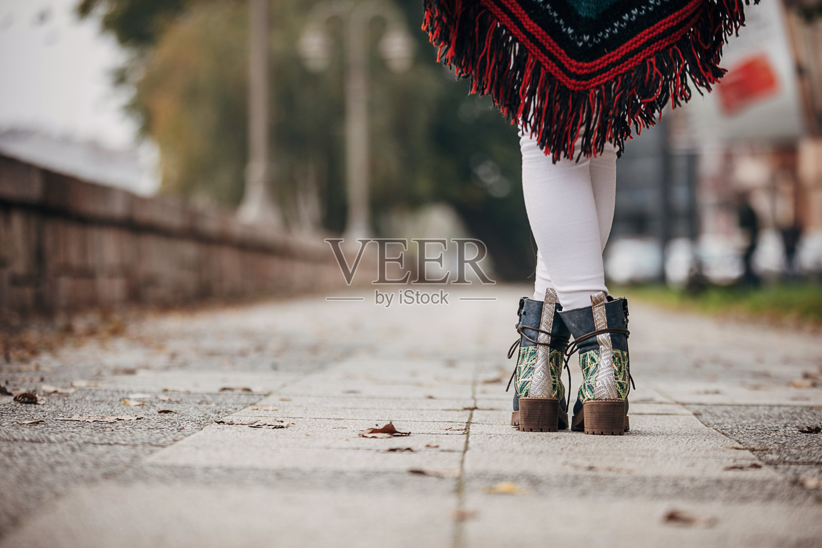 穿着时髦靴子站在街上的女人照片摄影图片