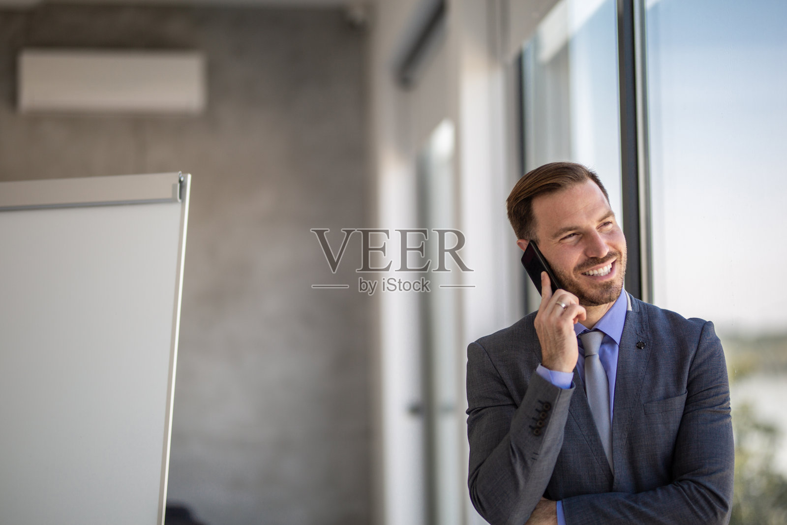 商人在现代的办公室里用手机进行商务联系照片摄影图片