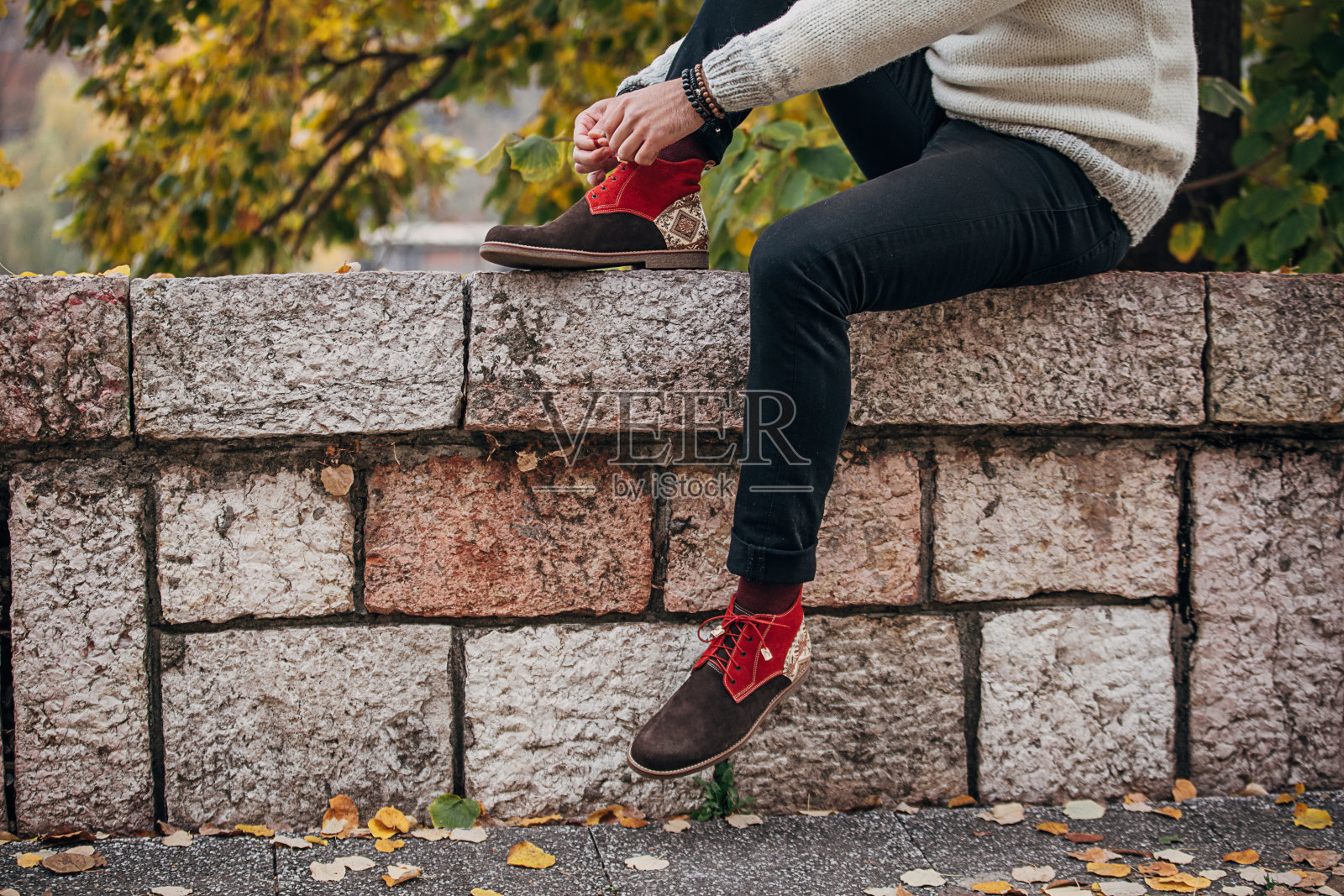 在户外系鞋带的男人照片摄影图片