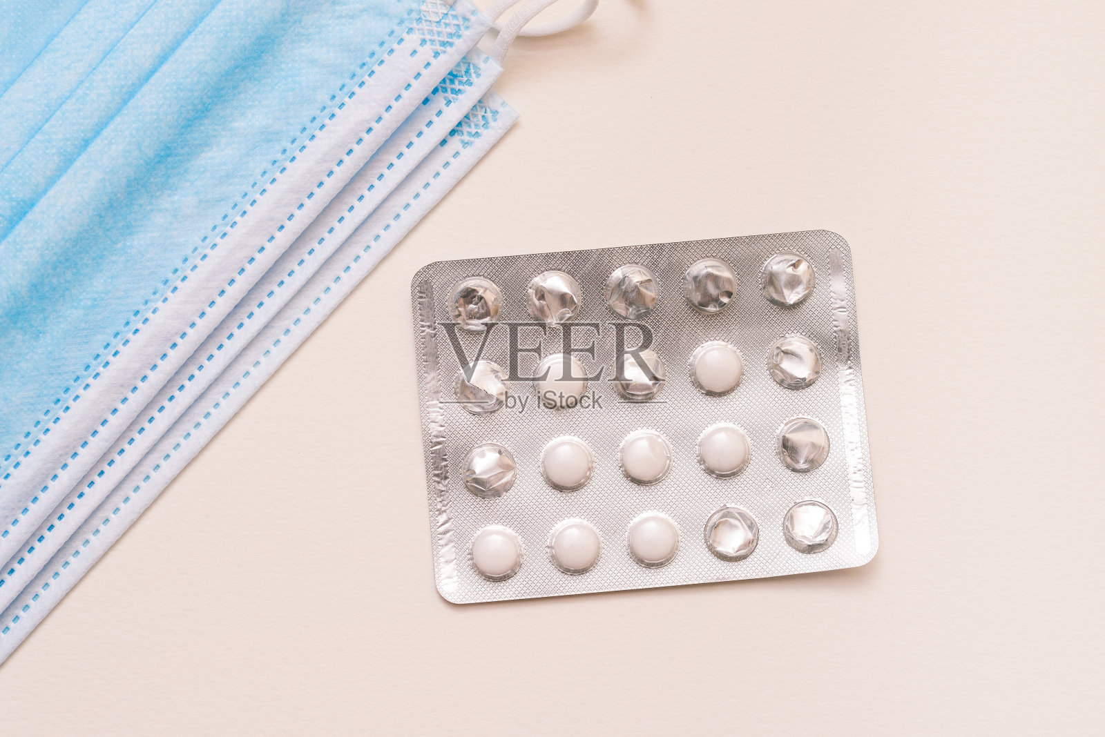 白色背景上的药片和一次性医用口罩包装。疾病治疗的概念。药品、药品。医学及卫生保健照片摄影图片