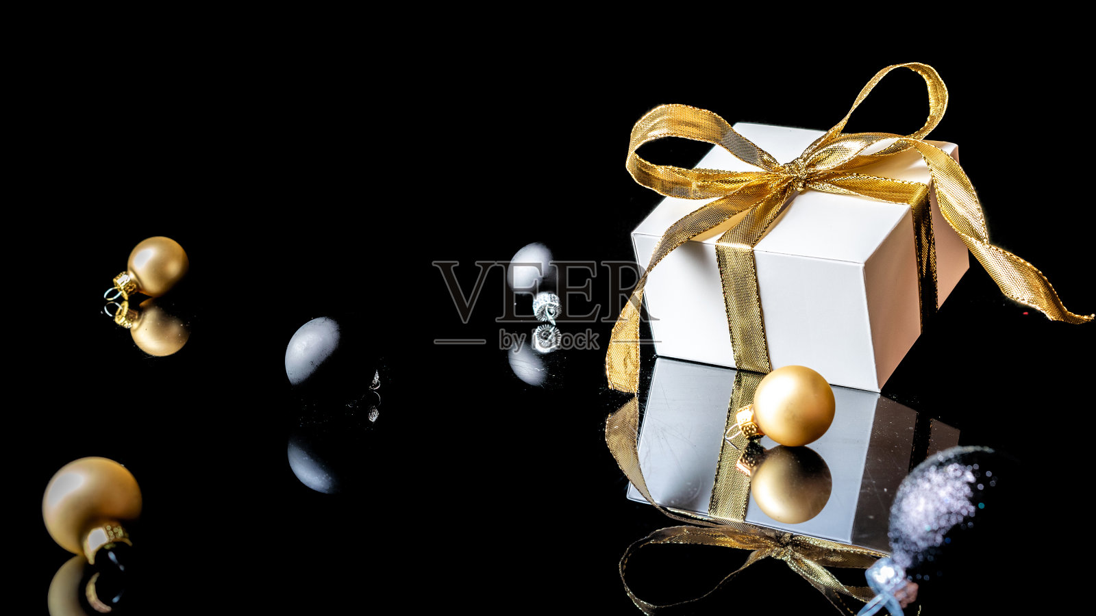 圣诞花环。白色的礼物与金色的弓，金色的球和新年树在圣诞装饰在黑暗的背景贺卡。文本的装饰和复制空间。照片摄影图片