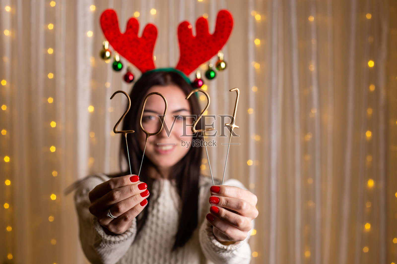 微笑可爱的女人拿着闪闪发光的2021年假期照片摄影图片