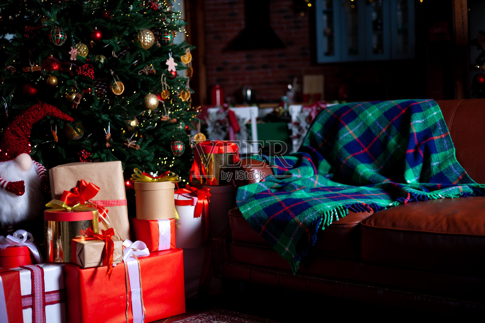 装饰着彩灯和礼物的圣诞树。家里舒适的假期。新年的气氛。花环闪闪发光。圣诞节的背景照片摄影图片