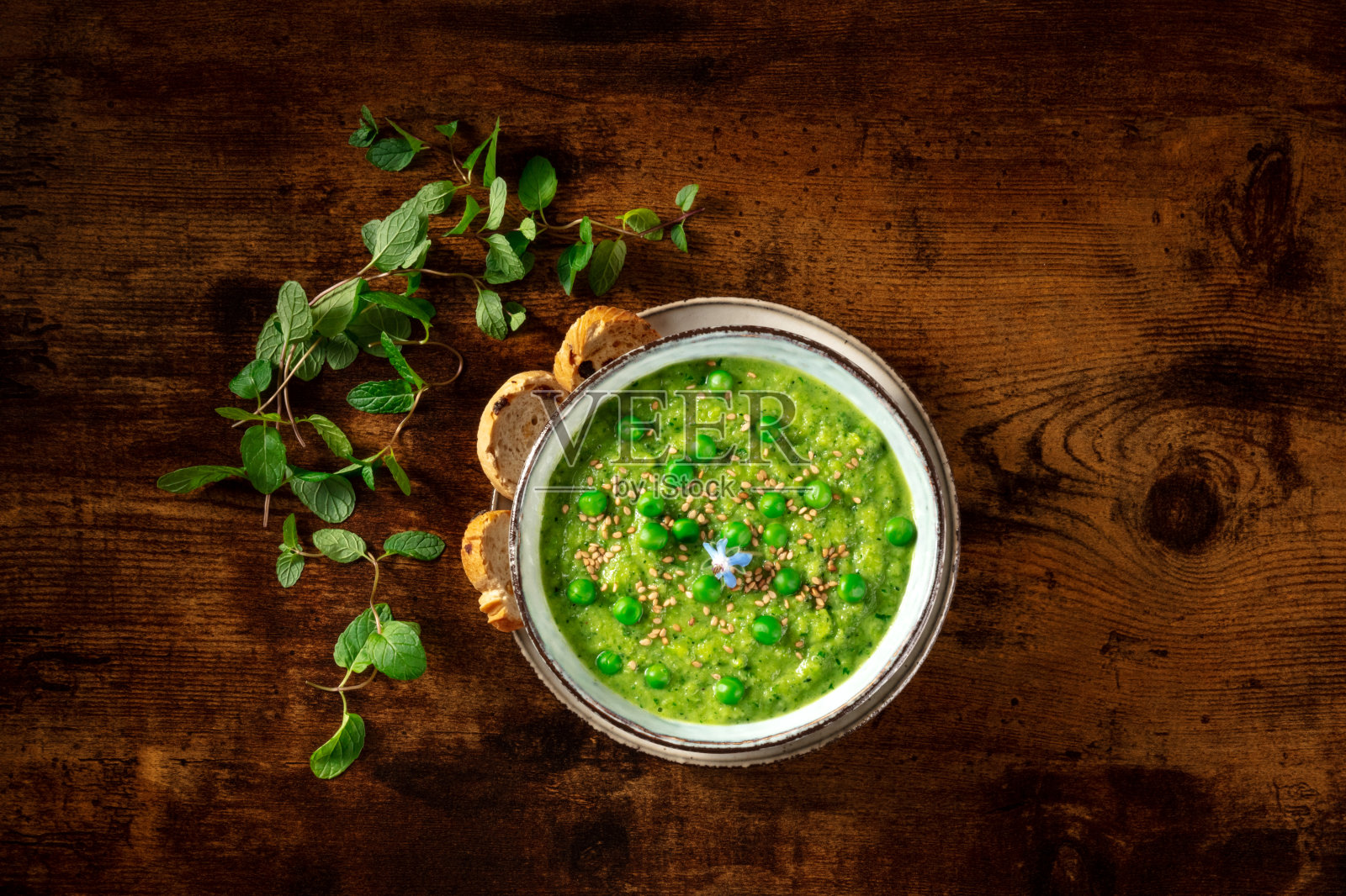 绿色奶油汤，从上方拍摄在一个黑色的乡村木制背景照片摄影图片