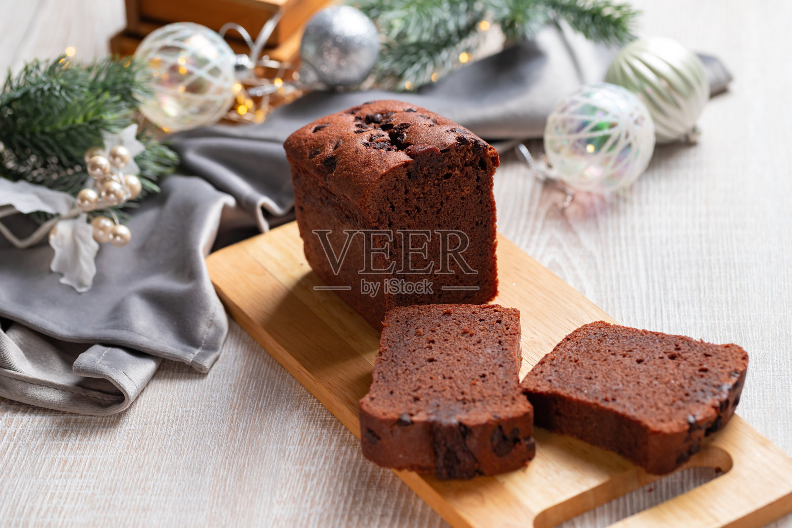 灰色的圣诞餐桌上放着几片巧克力蛋糕。照片摄影图片