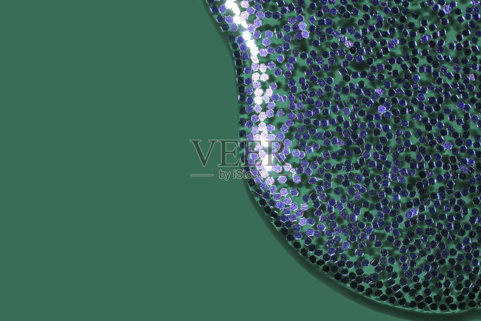 把紫色的闪光液体倒在潮水般的绿色背景上照片摄影图片