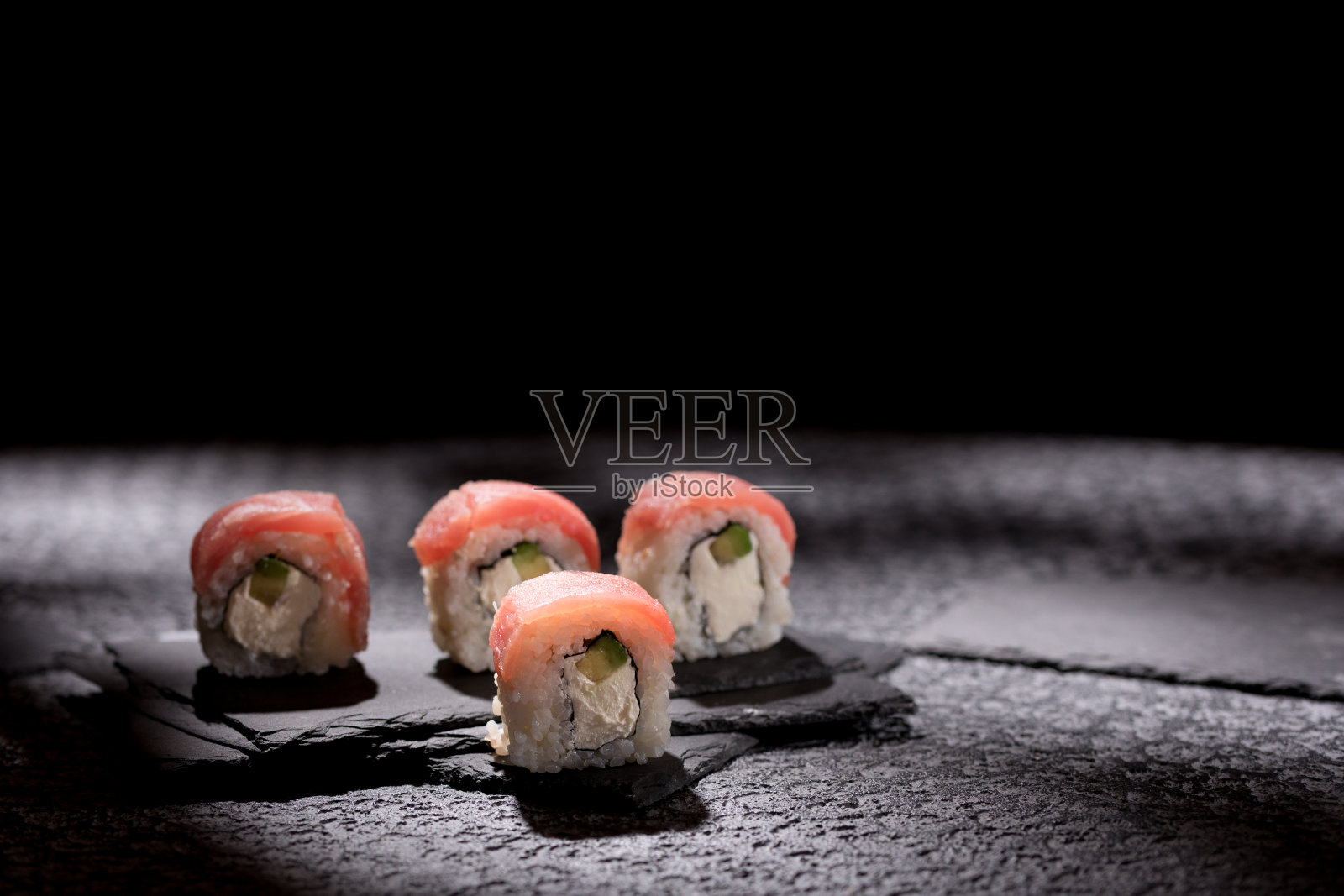 美味的面包卷上有纹理的黑色背景。日本食品的概念。特写镜头。副本的空间。照片摄影图片