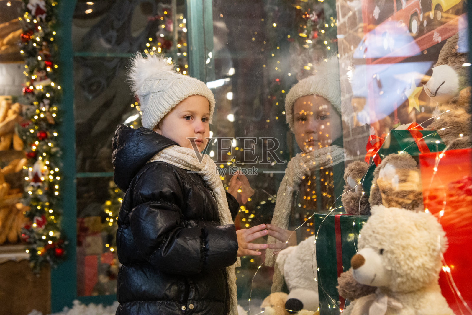 好奇的孩子在看商店橱窗里的玩具照片摄影图片