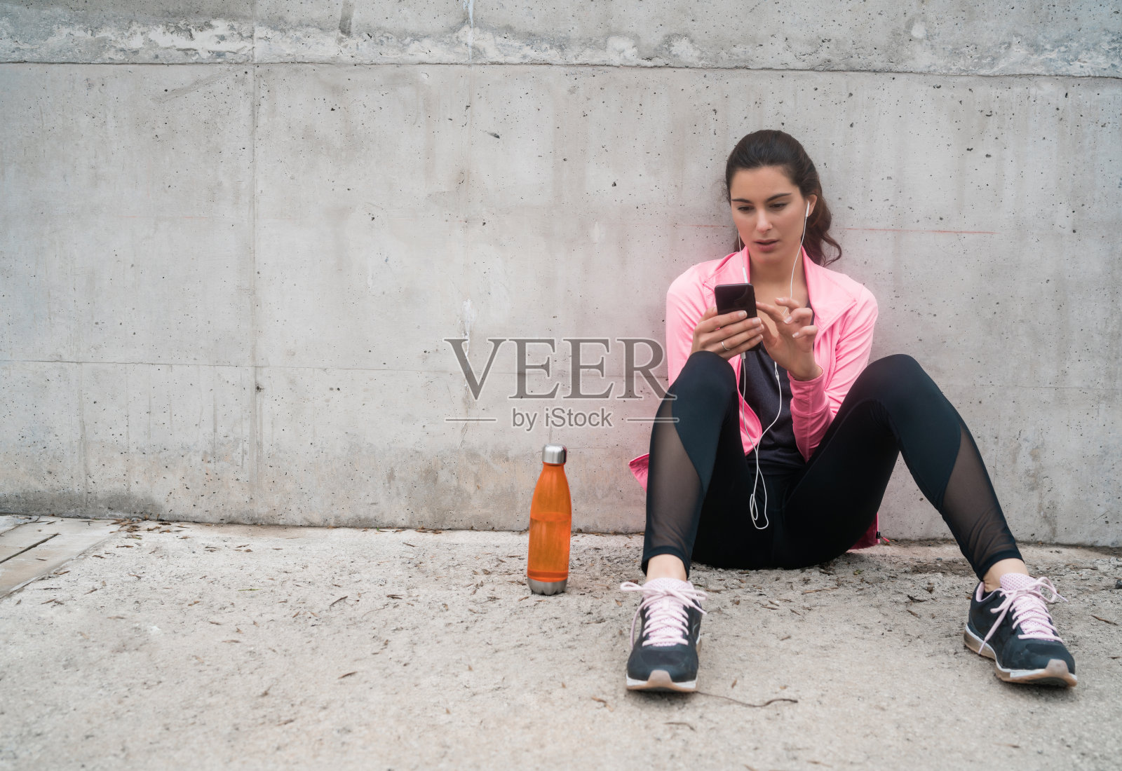 运动女性用手机。照片摄影图片