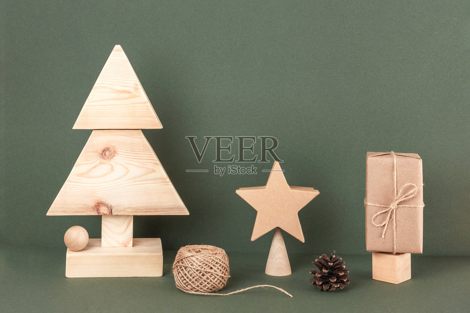 圣诞和新年作文。自制的木制圣诞树和节日装饰在绿色的背景。创意概念的假期。前视图照片摄影图片