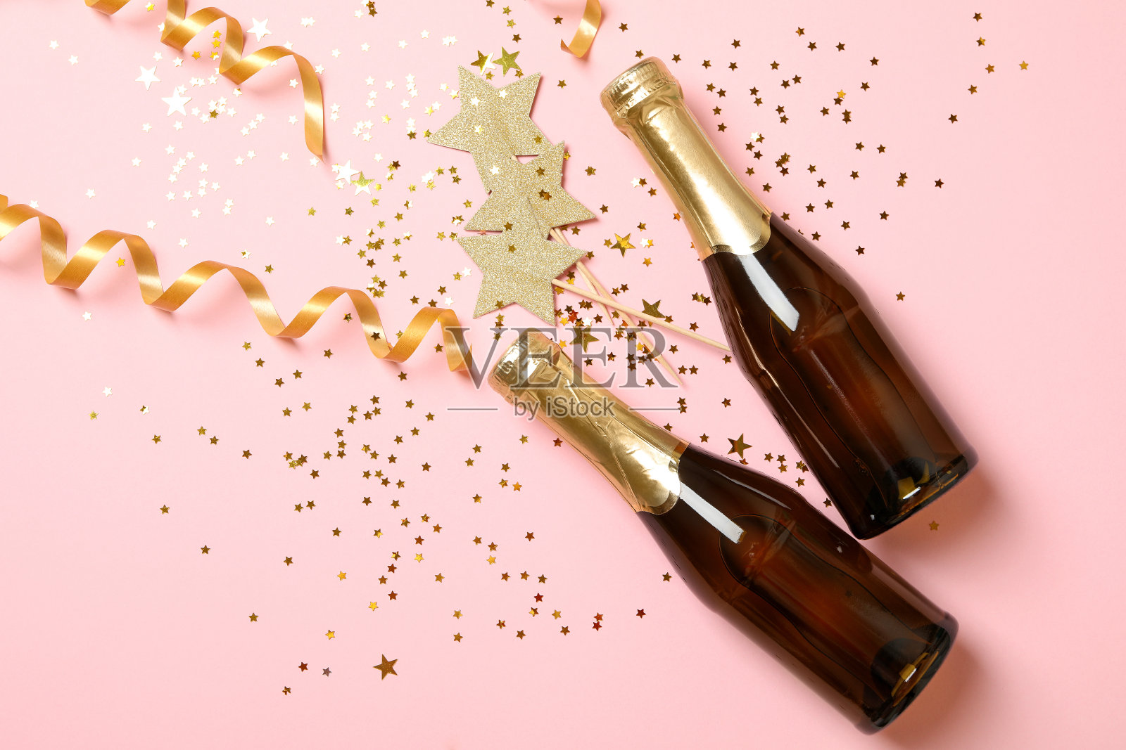 香槟酒瓶，粉红色背景下闪闪发光照片摄影图片