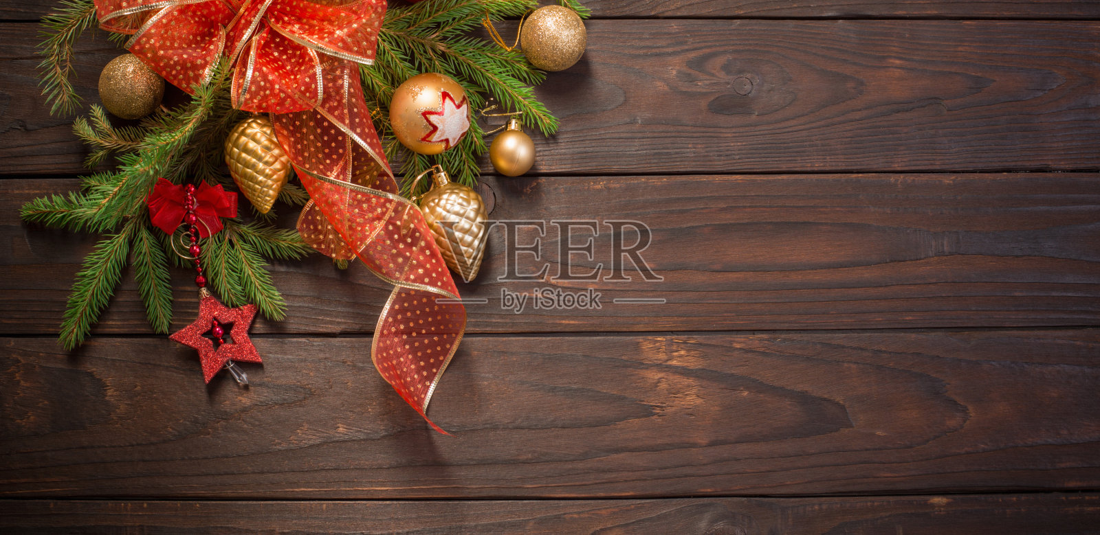 红色和金色的圣诞装饰与燃烧的蜡烛在木制的背景照片摄影图片