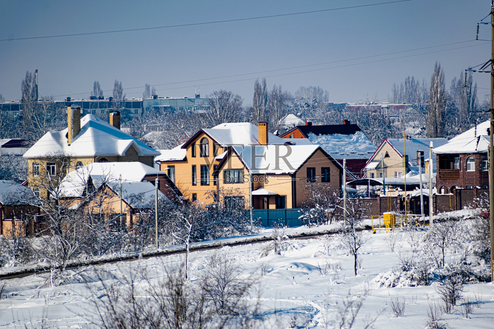 多层的住宅建筑由白色和红色的砖和塑料窗户，站在一层皑皑白雪下的冬天照片摄影图片