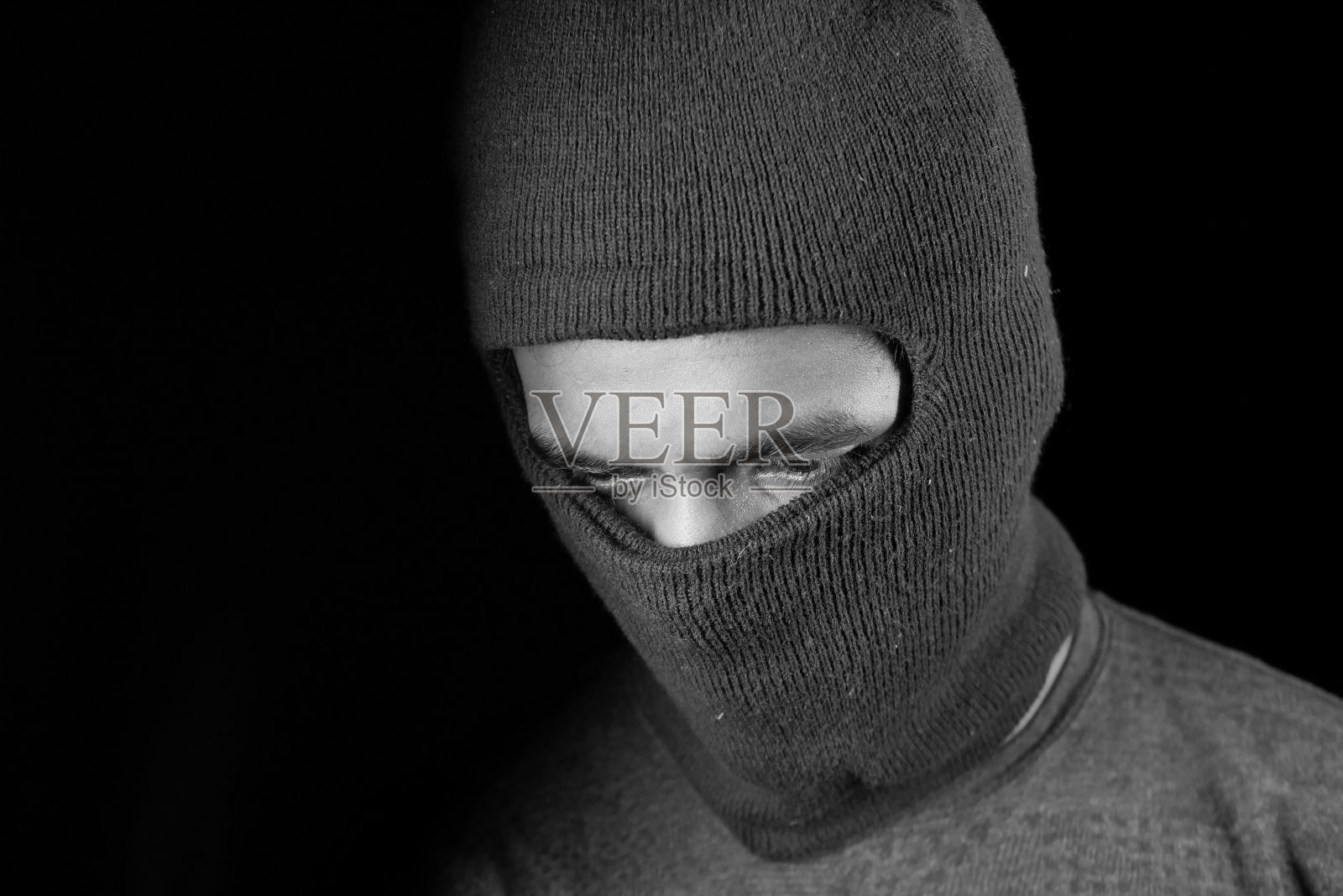 黑色背景下的面具小偷，照片摄影图片