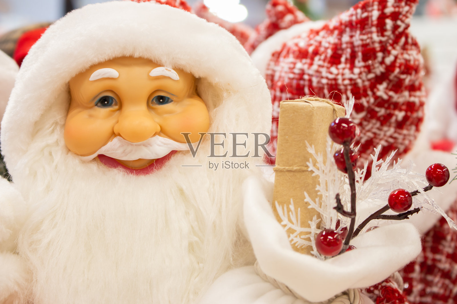 圣诞老人带着礼物。微笑的圣诞老人娃娃。圣诞装饰。商店里有圣诞老人玩具。新年快乐理念。寒假节日装饰。圣诞礼物。节日购物。照片摄影图片