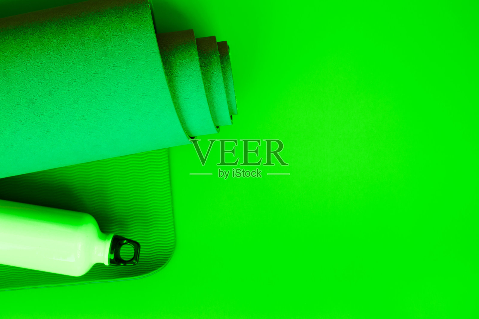 翠绿的背景上，亮绿色的深蓝色瑜伽垫照片摄影图片