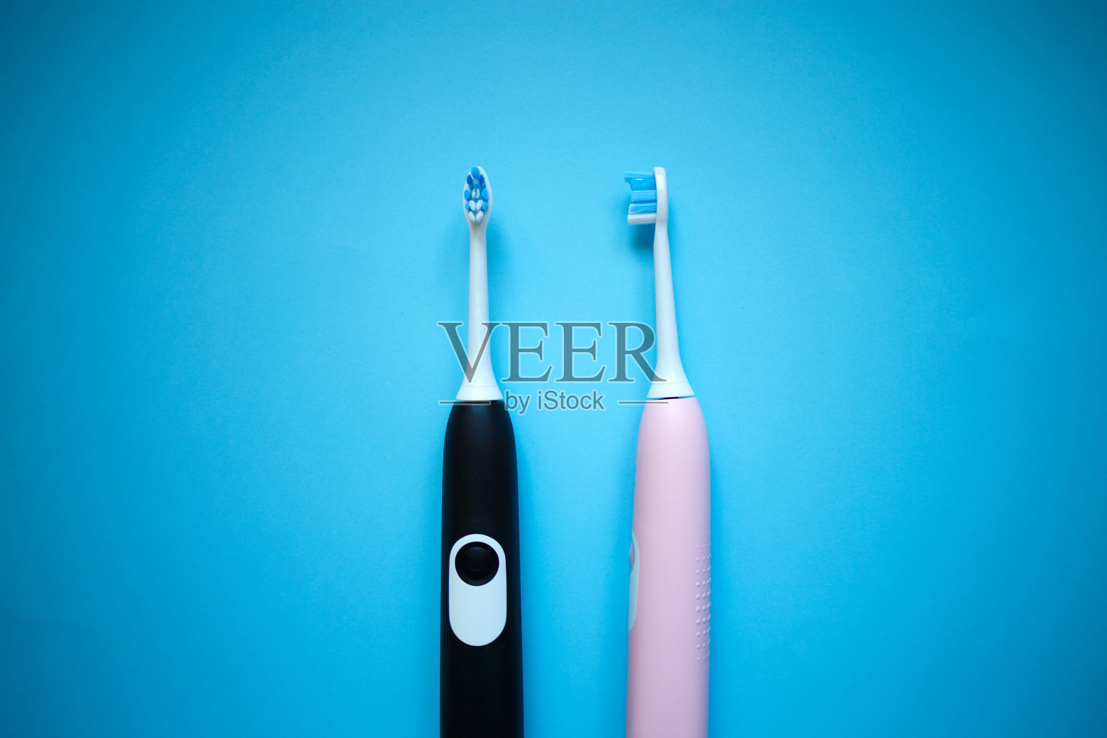 蓝色背景上有两把超声波电动牙刷照片摄影图片