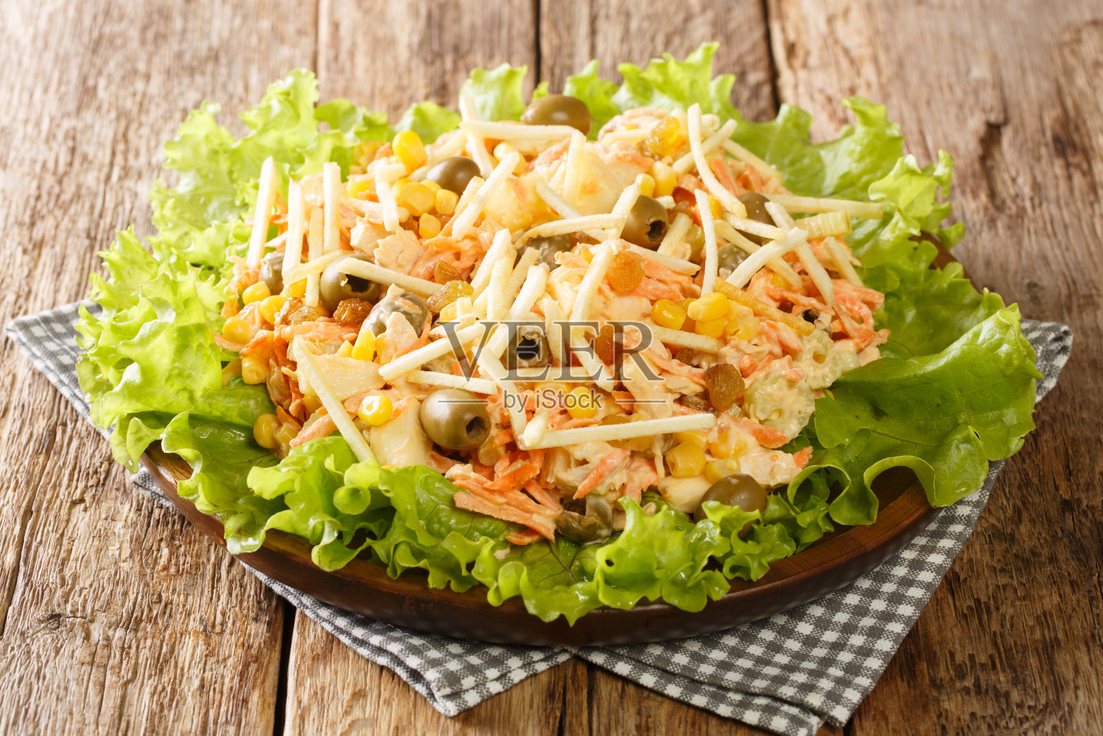 在餐桌上享用由鸡肉、蔬菜、葡萄干、橄榄和土豆条组成的自制Salpicao沙拉。水平照片摄影图片