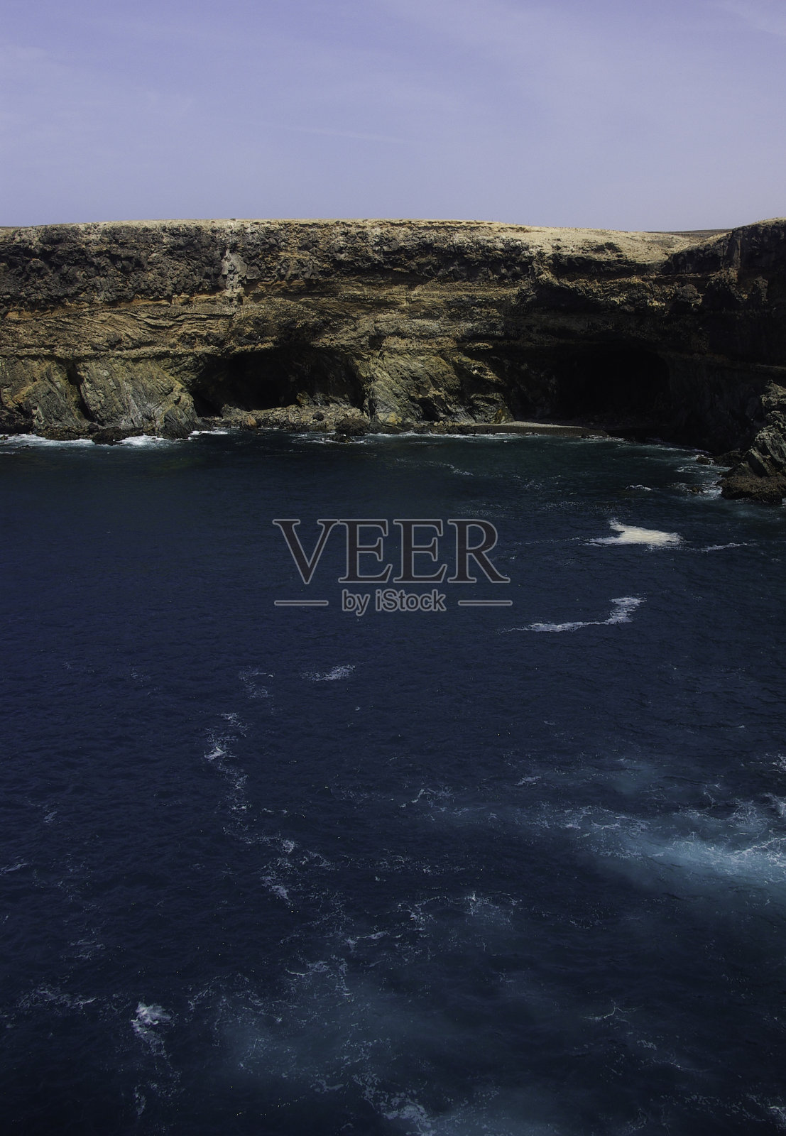 通往被岩石和大海包围的阿秋洞穴的路。照片摄影图片