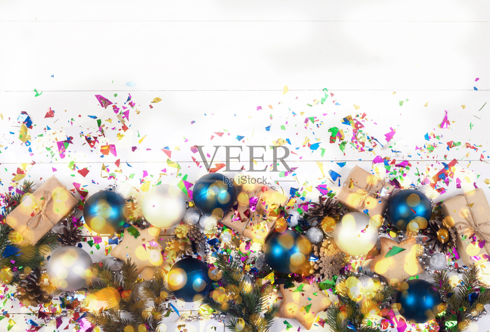 新年和圣诞节的装饰是用冷杉树枝、圆锥形、珠子、闪光粉、蓝色和银球在白色的背景上做成的。副本的空间。照片摄影图片