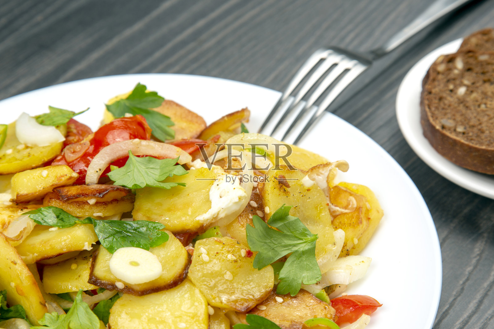 煎土豆，配香草和蔬菜放在盘子里照片摄影图片