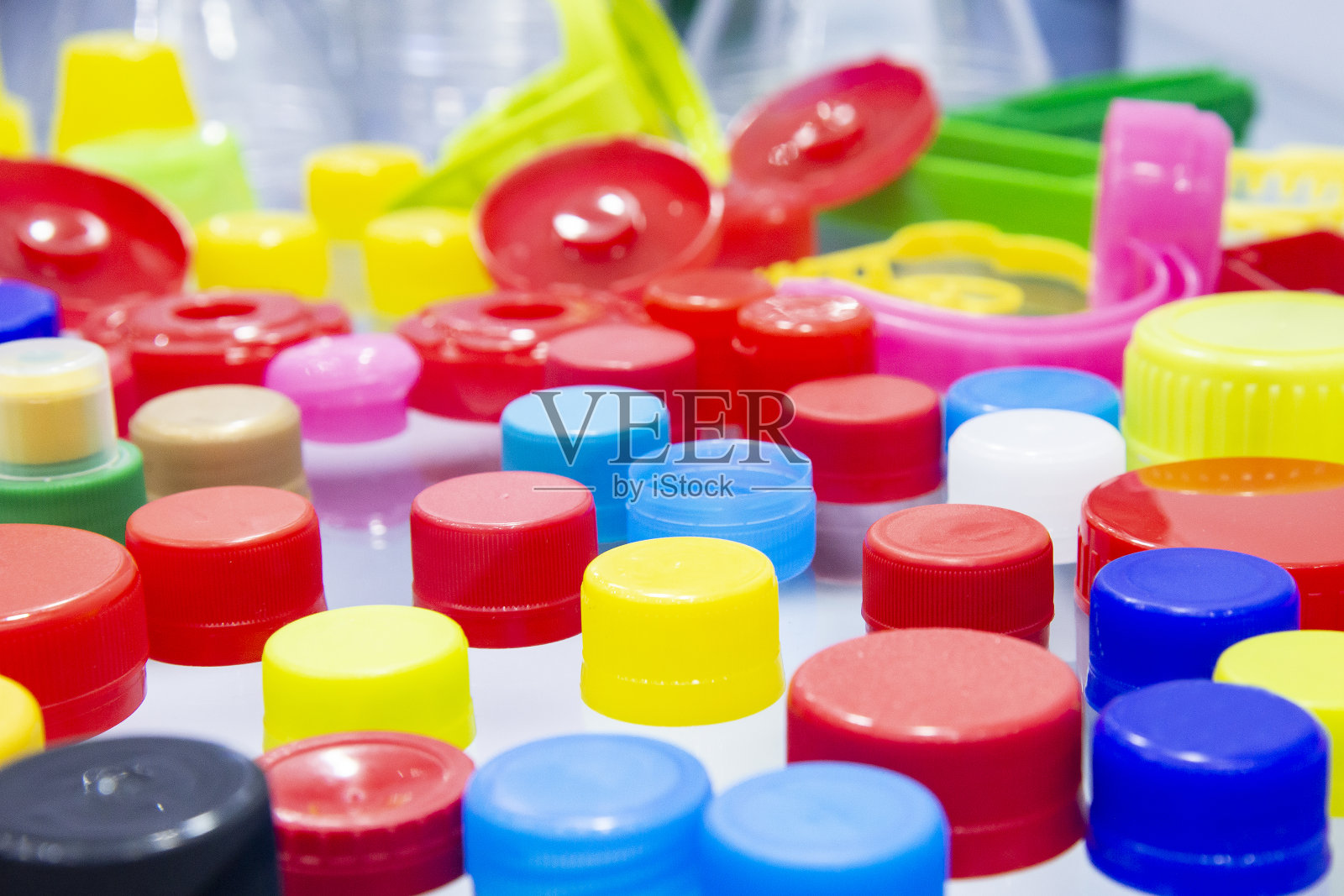 堆的多色塑料帽。照片摄影图片