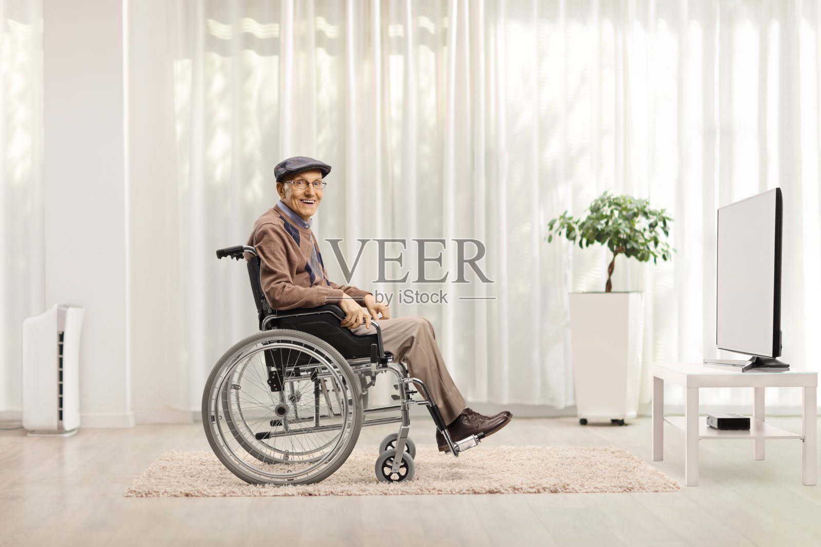 坐在轮椅上的老人坐在电视机前照片摄影图片