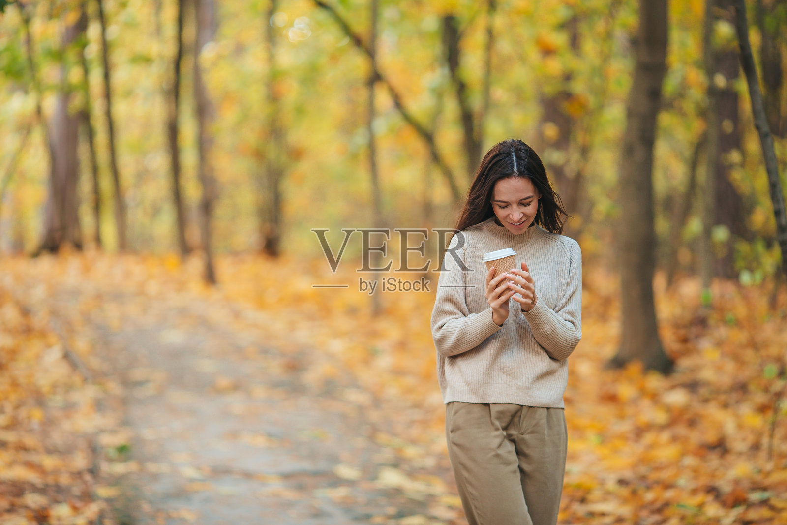 秋天的概念-美丽的女人在秋天的树叶下喝咖啡秋天公园照片摄影图片