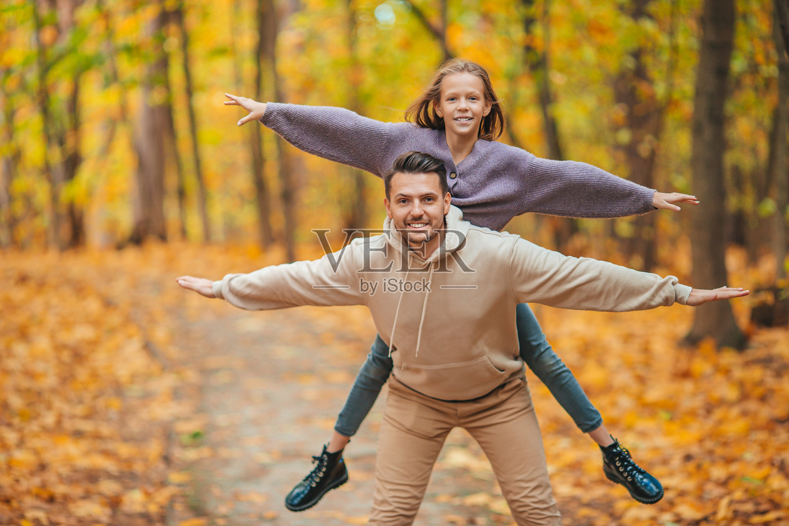 爸爸和孩子的家庭在公园里美丽的秋日照片摄影图片