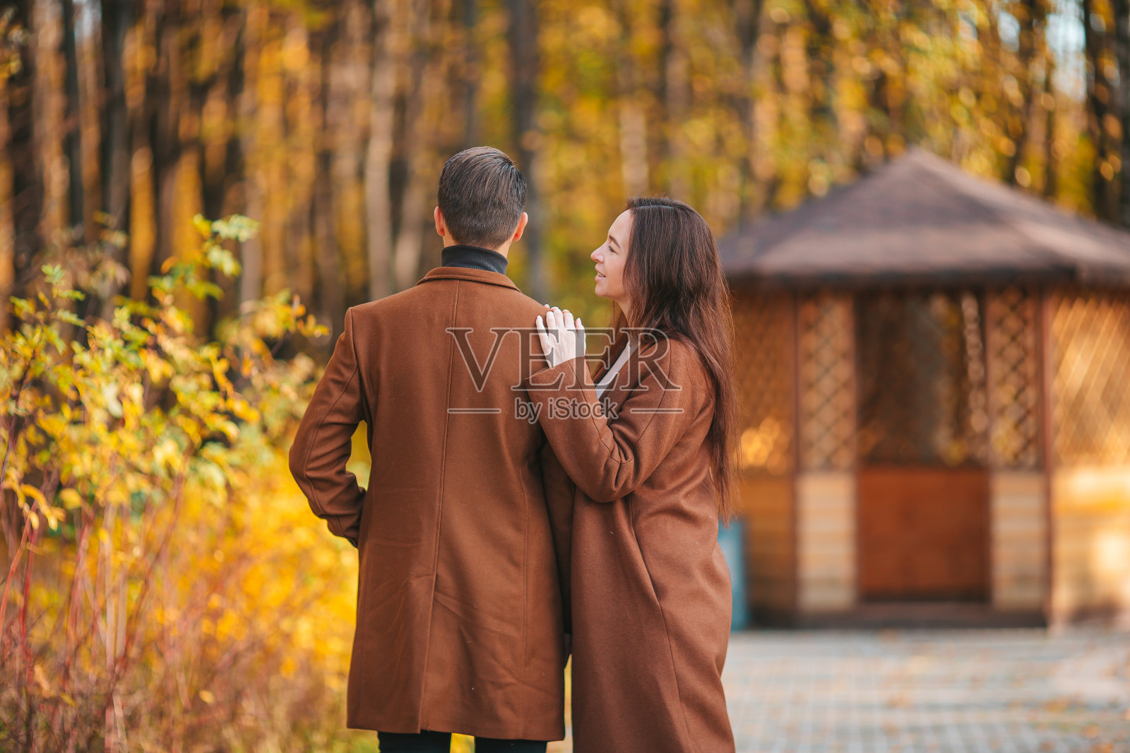 快乐的一家人在阳光明媚的秋天公园散步照片摄影图片