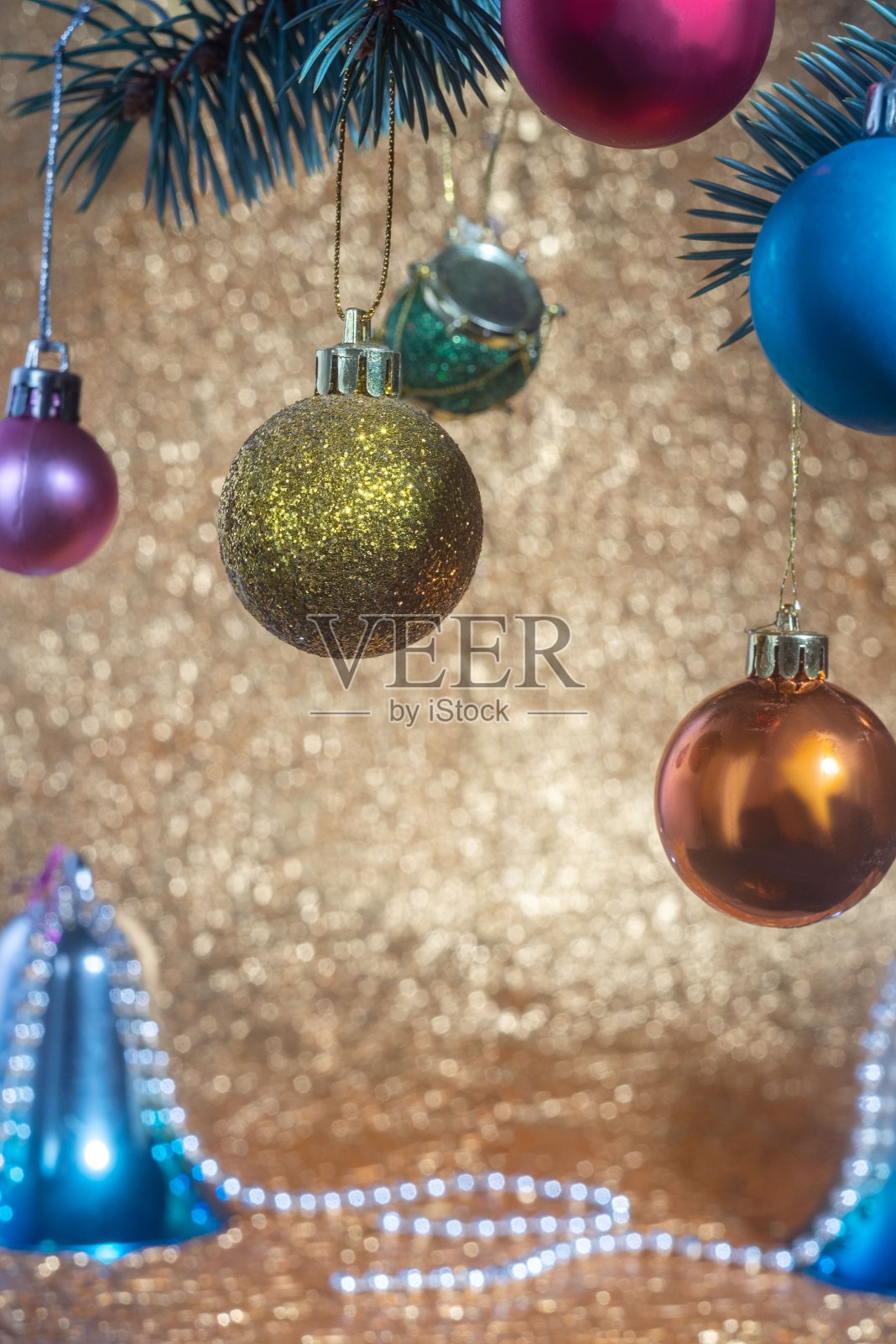 新年的五颜六色的玩具在冷杉上。金色的圣诞背景，钟声照片摄影图片