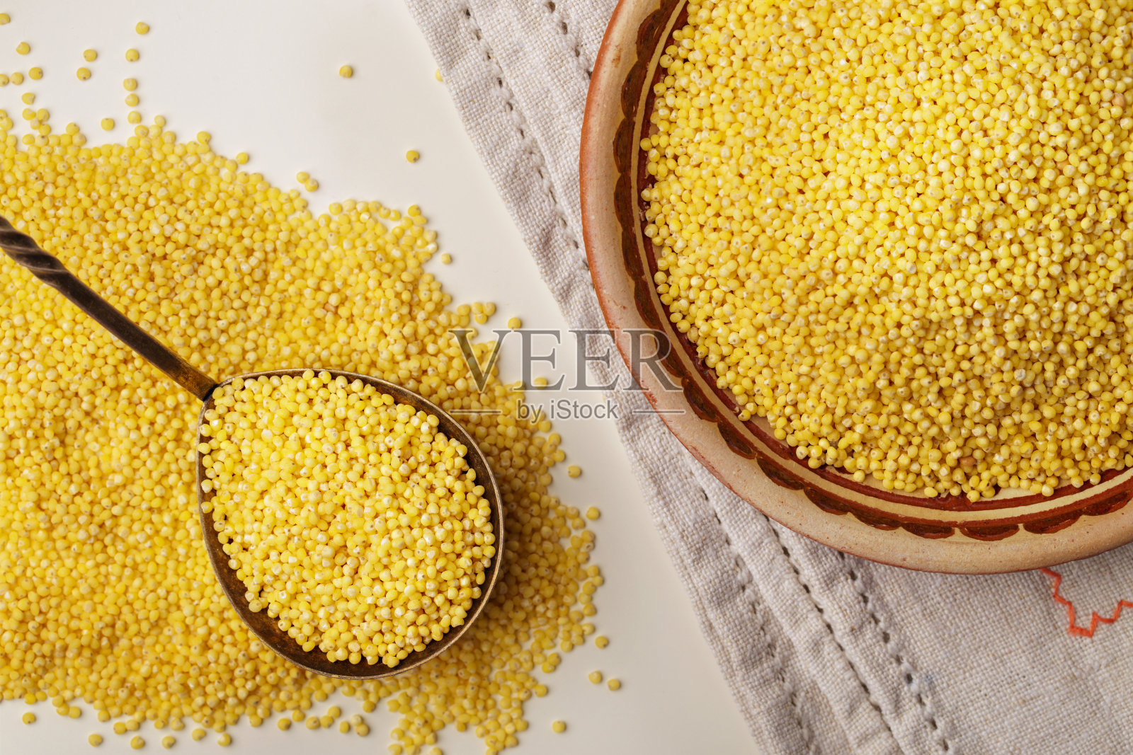勺子和盘子上的小米或谷粒，近景，俯视图照片摄影图片