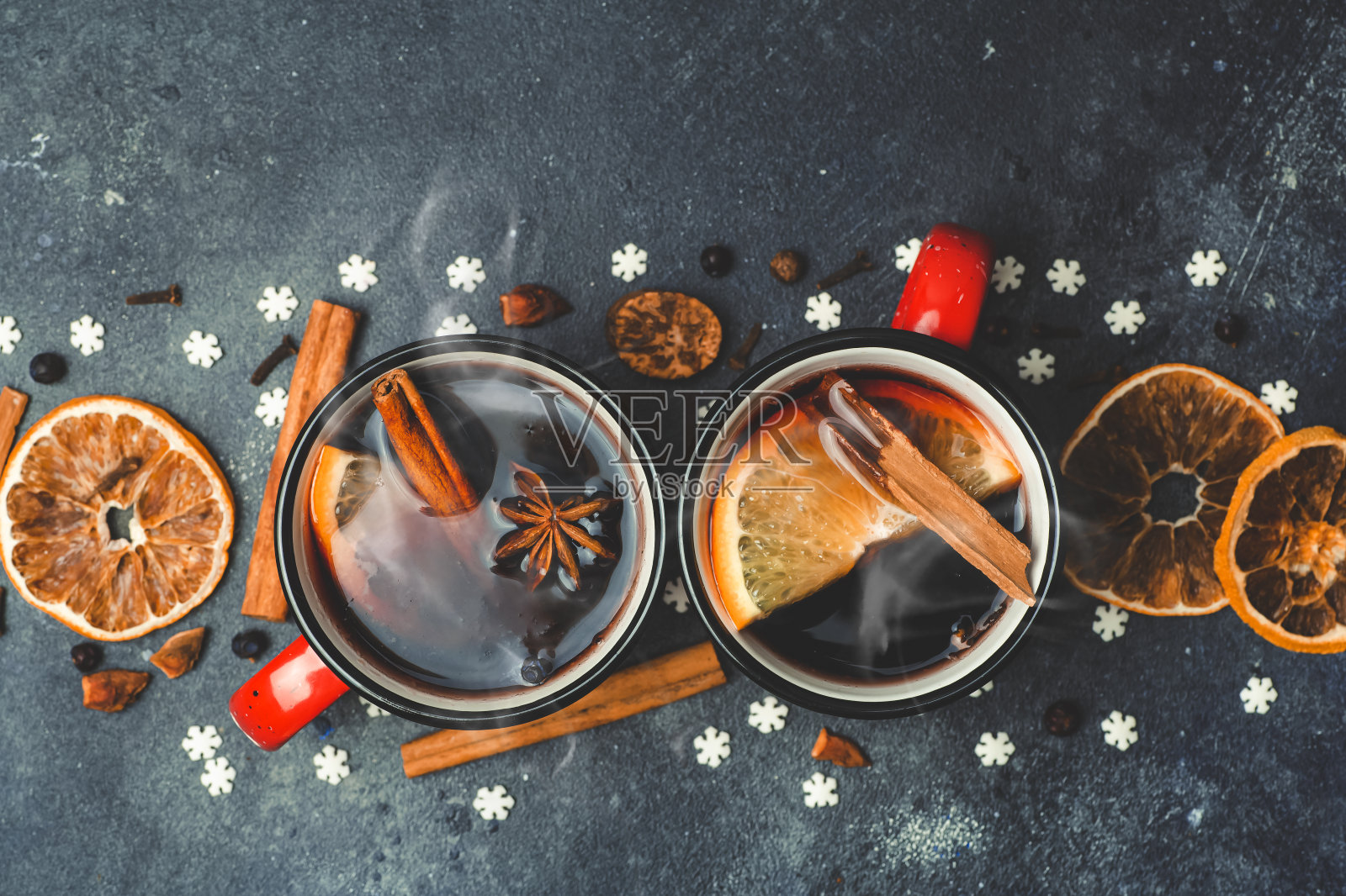 加香料的热葡萄酒背景。一种用红酒、香料和柑橘类水果制成的冬季圣诞热饮。照片摄影图片