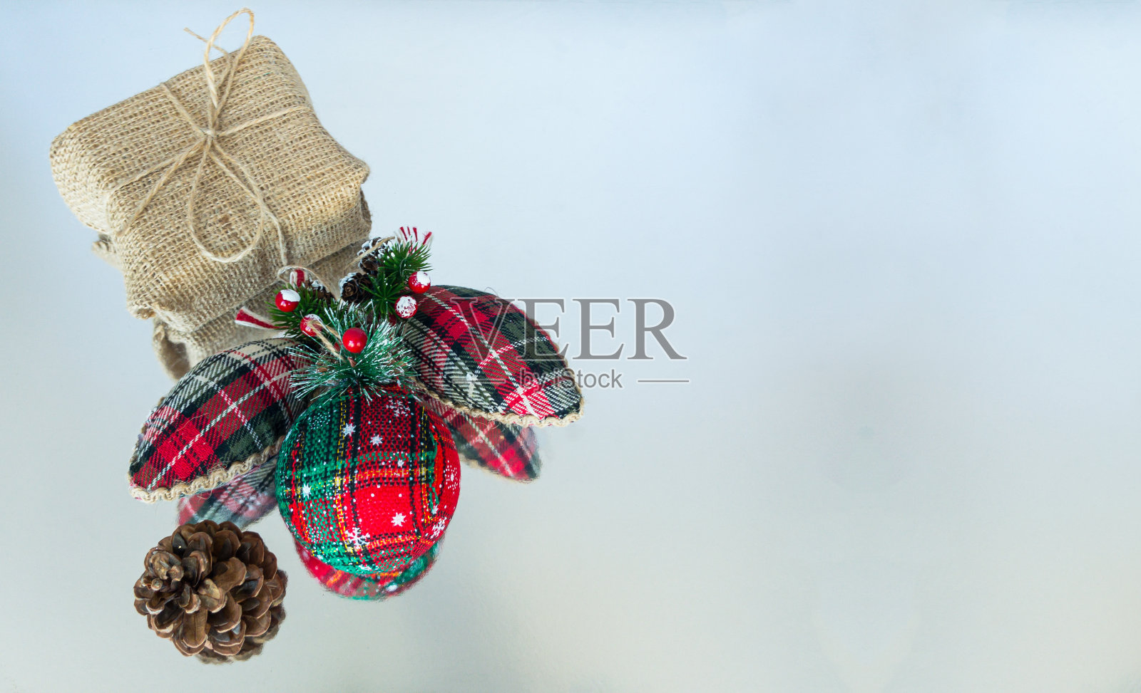 圣诞装饰品和松果在一个乡村礼盒前的反光表面照片摄影图片