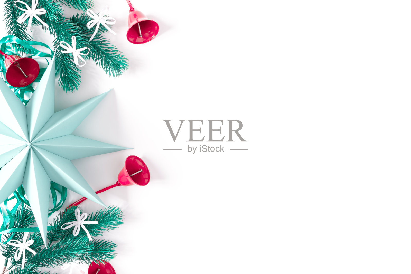 圣诞，新年作文。白色背景上有一颗巨大的纸星和冷杉树枝。模板上装饰着红色的铃铛和白色的蝴蝶结。平铺，俯视图，拷贝空间。照片摄影图片