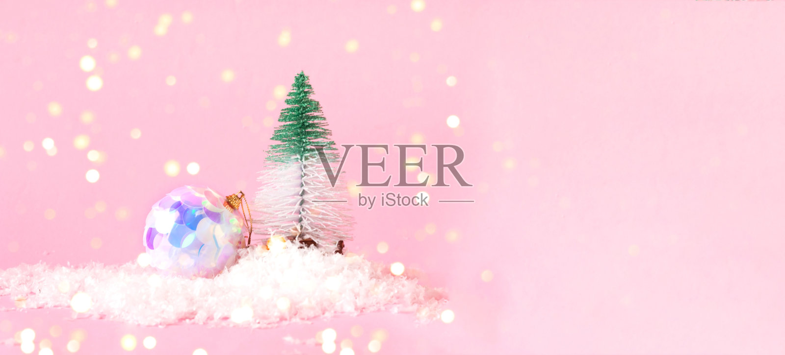 装饰圣诞树和霓虹球在粉红色的背景与雪。节日概念与模糊效果。空间创意副本。照片摄影图片