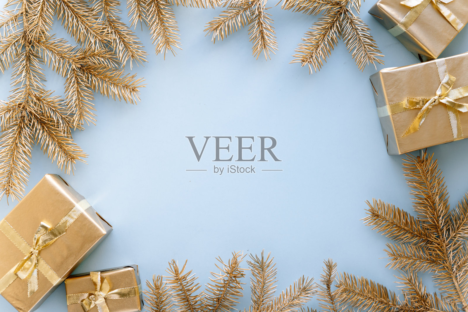 蓝色的圣诞或新年的背景，朴素的金色圣诞礼物和金杉树枝组成，平平的，空白的问候文字。圣诞节的概念。照片摄影图片