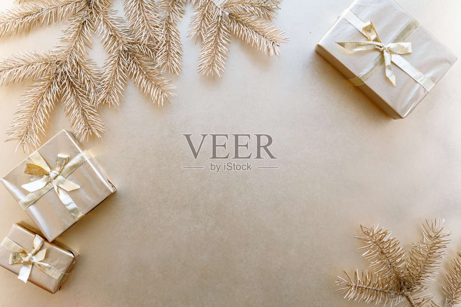 金色的圣诞或新年的背景，素朴的构成金色的圣诞礼物和金色的冷杉树枝，平平的，空白的问候文字。圣诞节的概念。照片摄影图片