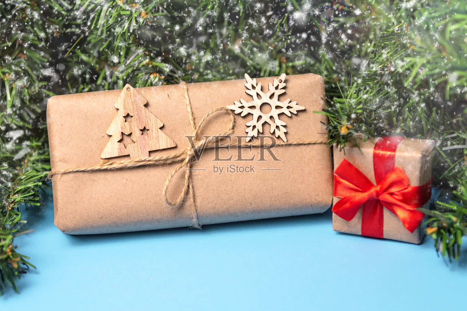 圣诞背景与礼物在牛皮纸和圣诞树在一个蓝色的背景。圣诞贺卡。寒假的主题。新年快乐。空间的文本照片摄影图片