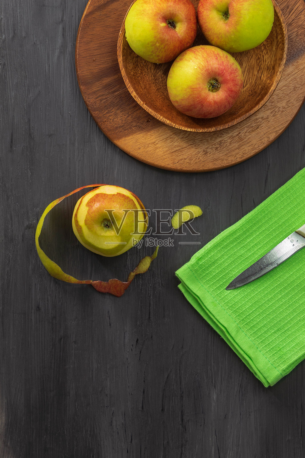 新鲜的苹果放在一个木碗里，背景是深灰色照片摄影图片