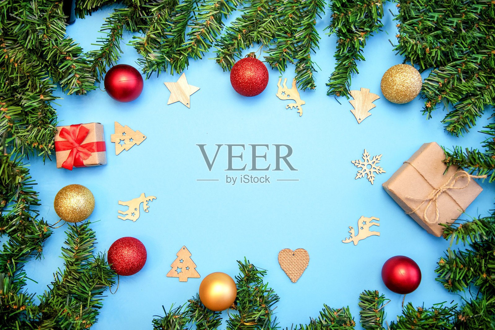 用冷杉树枝，金色和红色的气球，蓝色背景的木制玩具组成的圣诞作品照片摄影图片