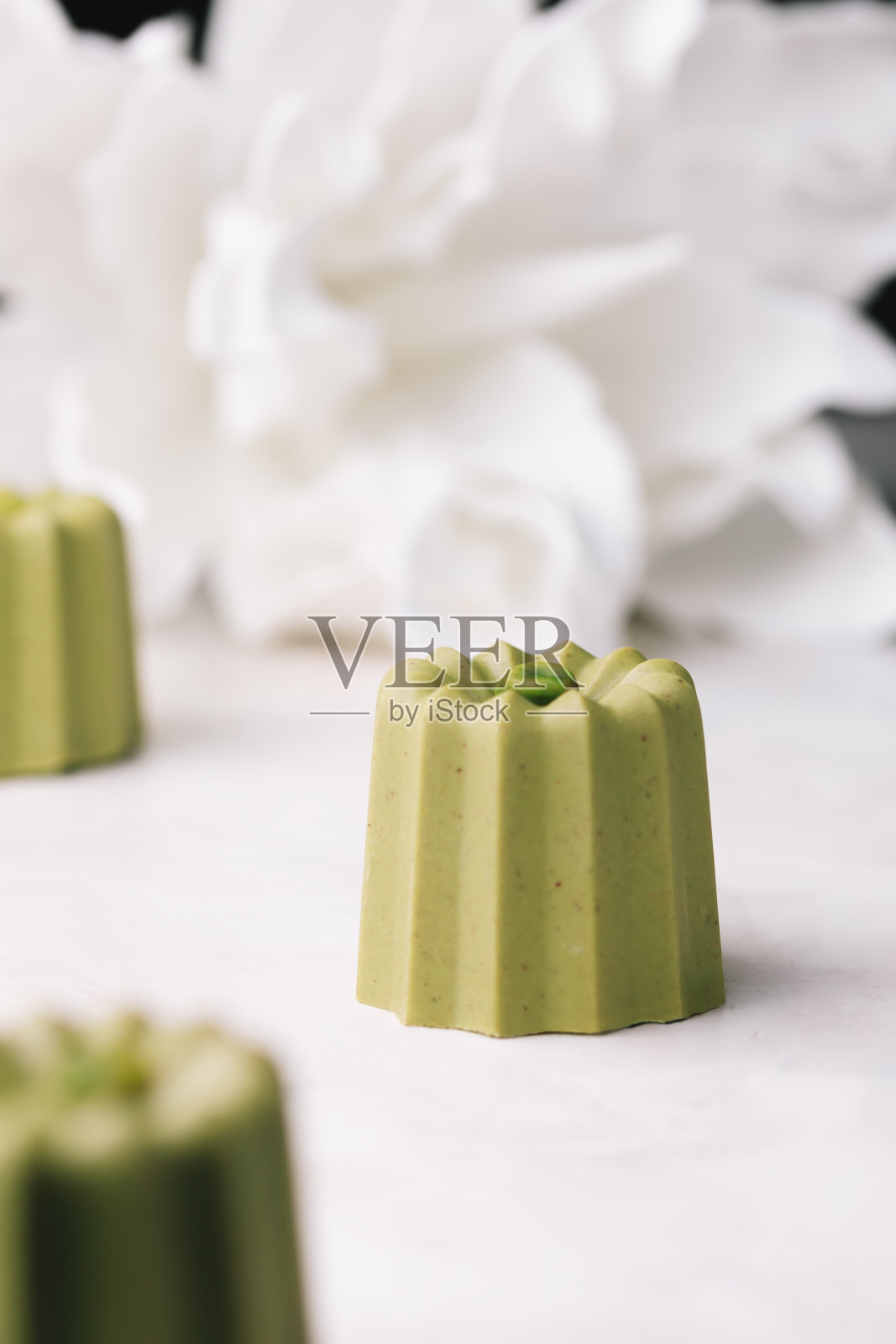 自制开心果杏仁小蛋糕(金融家)覆盖巧克力釉。现代欧洲糕点。照片摄影图片