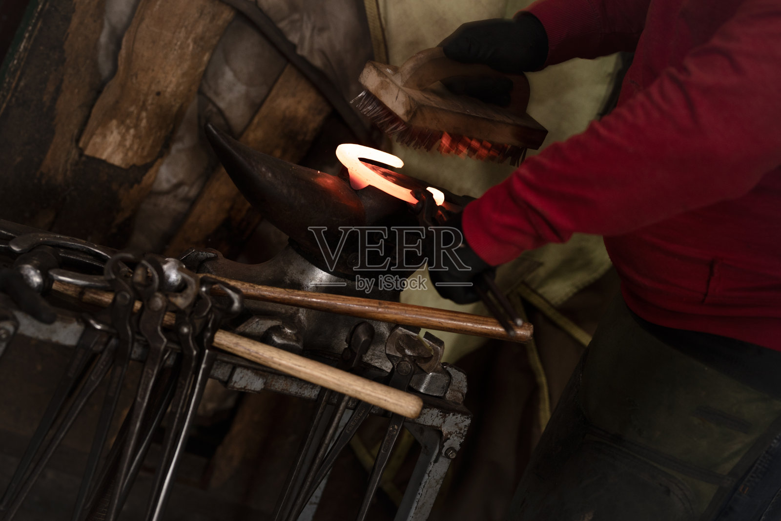 在铁砧上准备烧红的马蹄铁的人照片摄影图片
