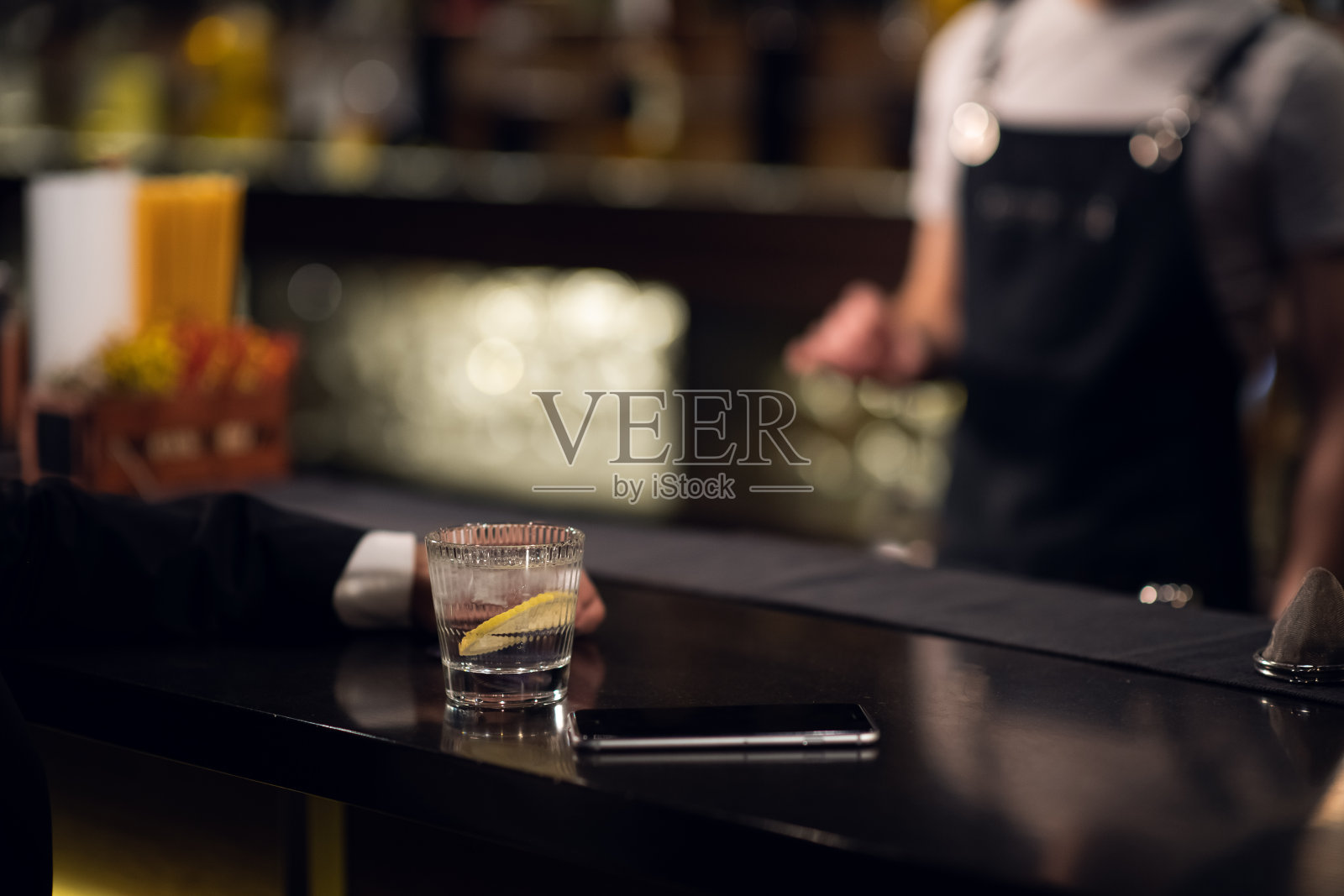 一杯水和柠檬，旁边的智能手机吧台靠近照片摄影图片