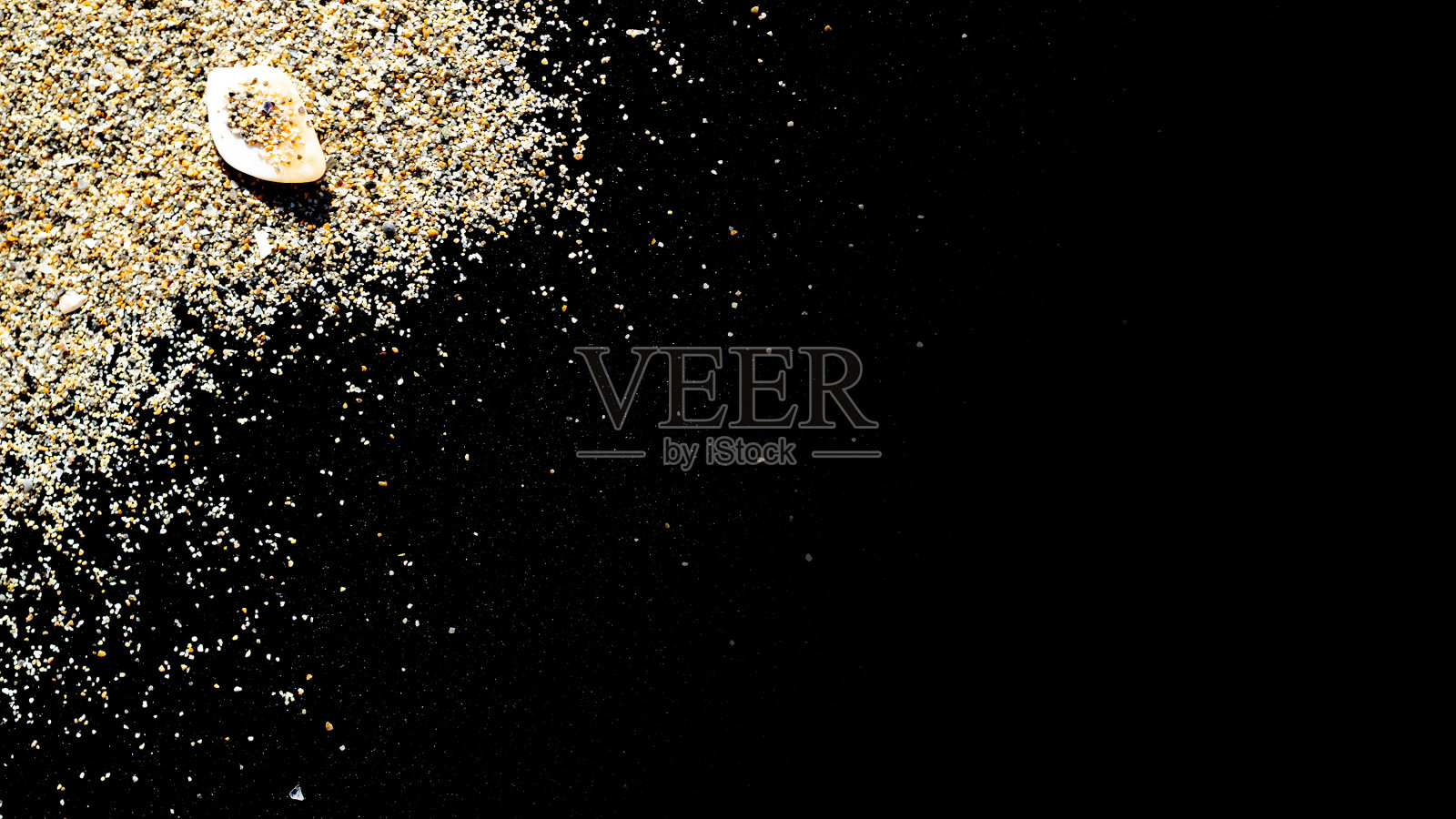 沙漠堆沙孤立在黑色。海滩背景上的灰尘堆海滩纹理。简约风格的旅游概念。照片摄影图片